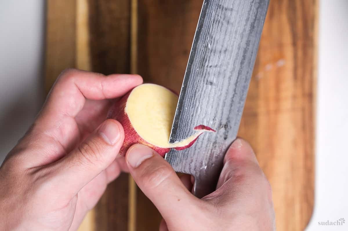 peeling/chamfering the edges of sweet potato rounds with a knife
