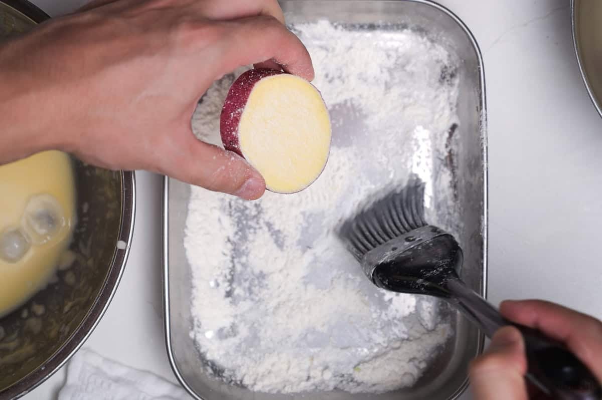 brushing a thick slice of Japanese sweet potato with cornstarch