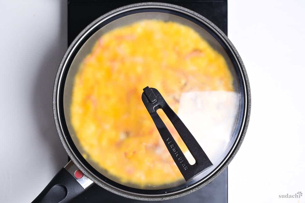 steaming crab omelette for tenshinhan in a frying pan topped with a lid