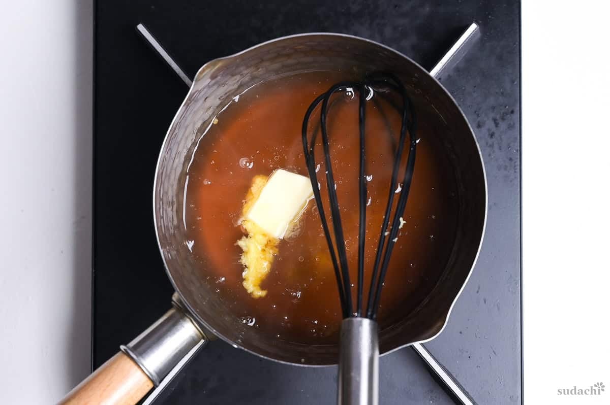 glossy tenshinhan sauce with butter and whisk in a saucepan on the stove