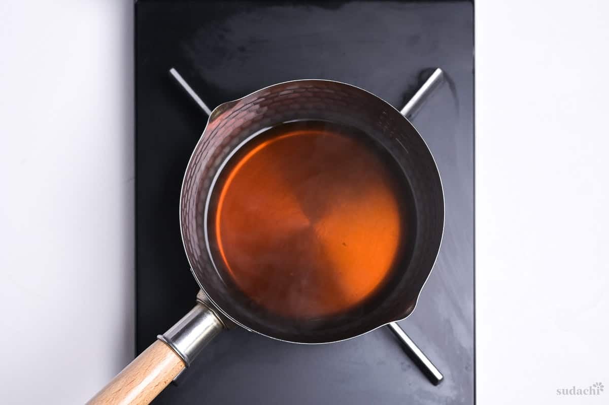 simmering homemade tsuyu sauce in a sauce pan on the stove top