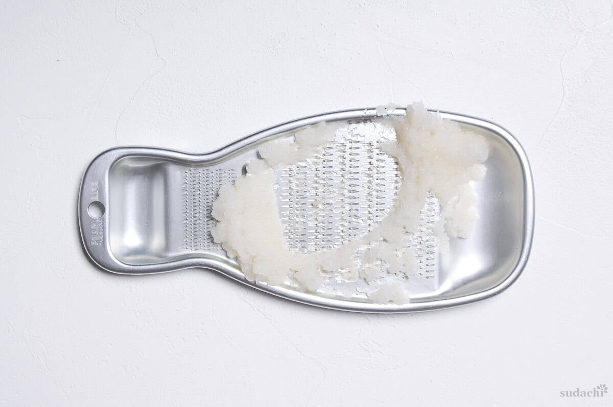 grated daikon radish on a silver Japanese oroshi grated