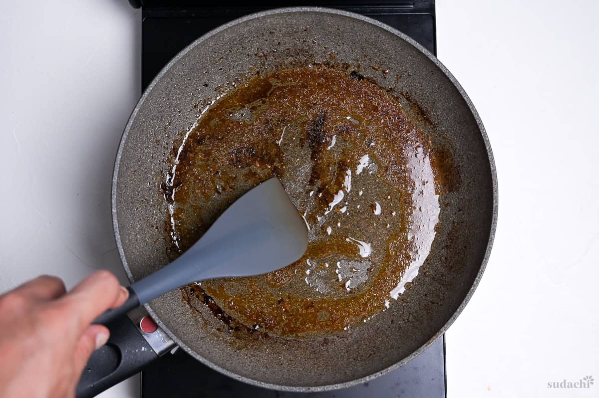 scraping fond from wafu hamburg from a frying pan with a silicone spatula