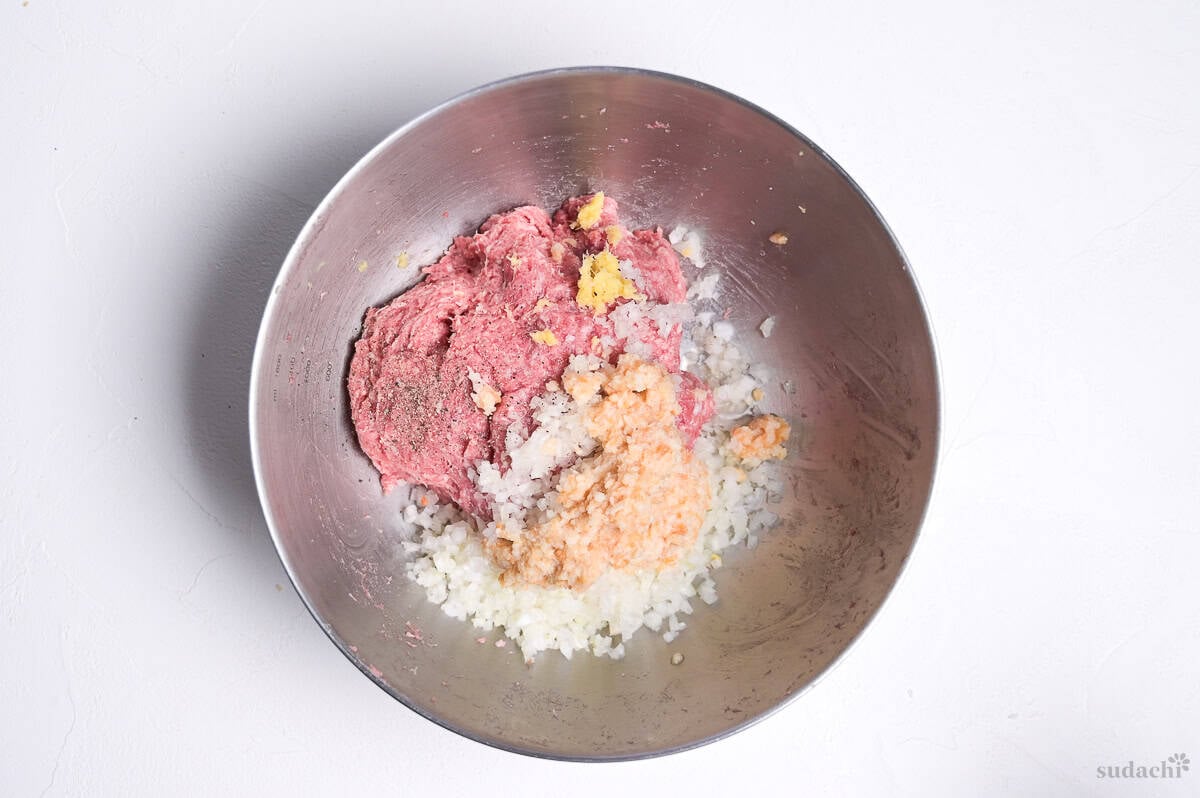ingredients to make wafu hamburg patties in a steel mixing bowl