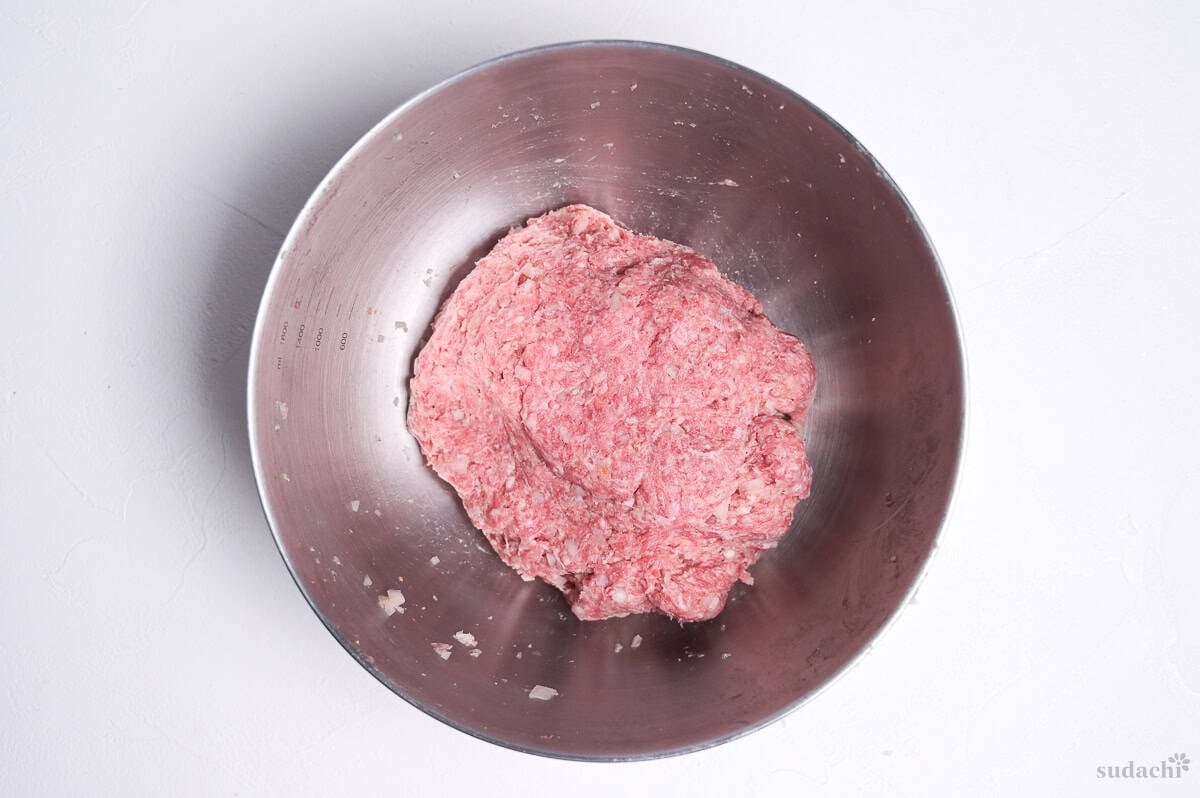 kneaded ground meat in a steel mixing bowl to make homemade wafu hamburg patties