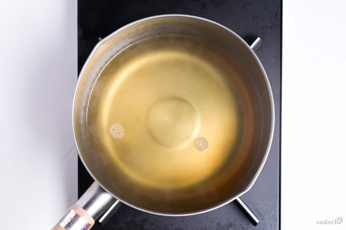 dashi and mirin in a pot on the stove top to make kake udon noodle soup