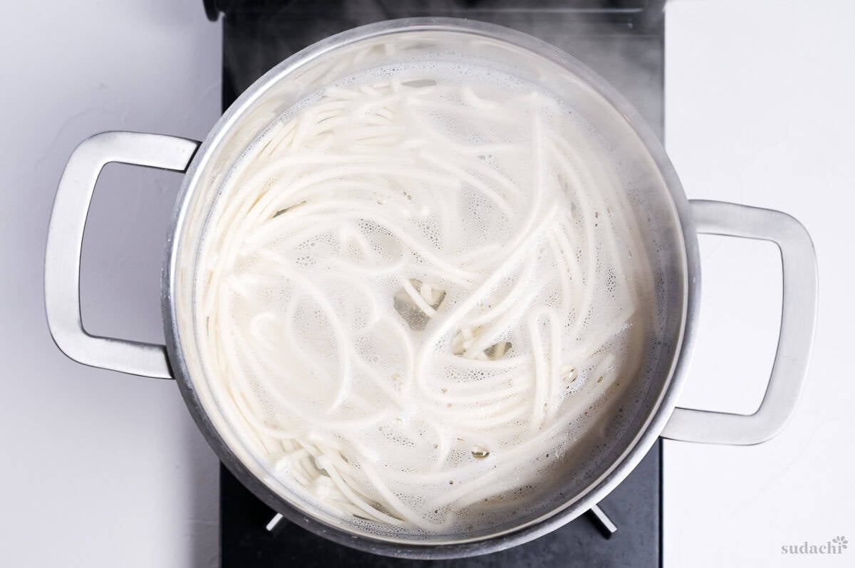 udon noodles boiling in a pot on the stove top