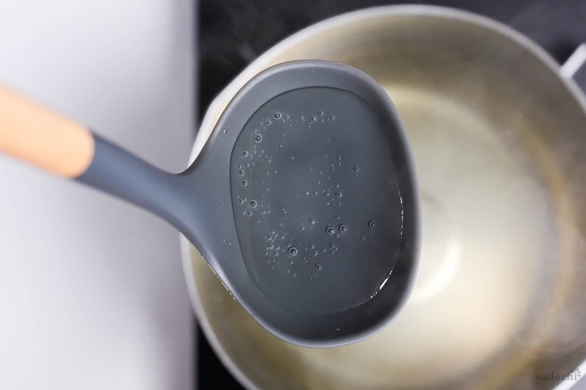 a close up of homemade dashi in a ladle
