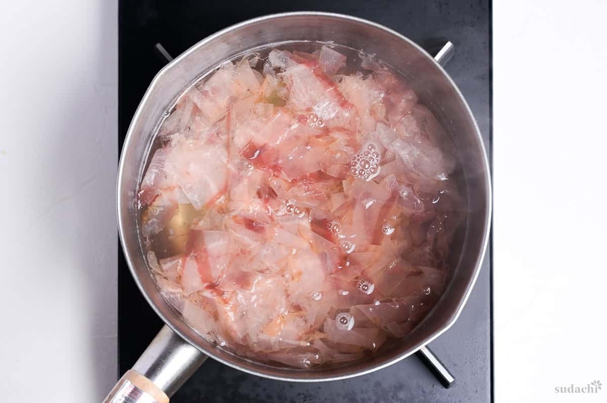katsuobushi steeping in hot dashi in a pot on the stove top
