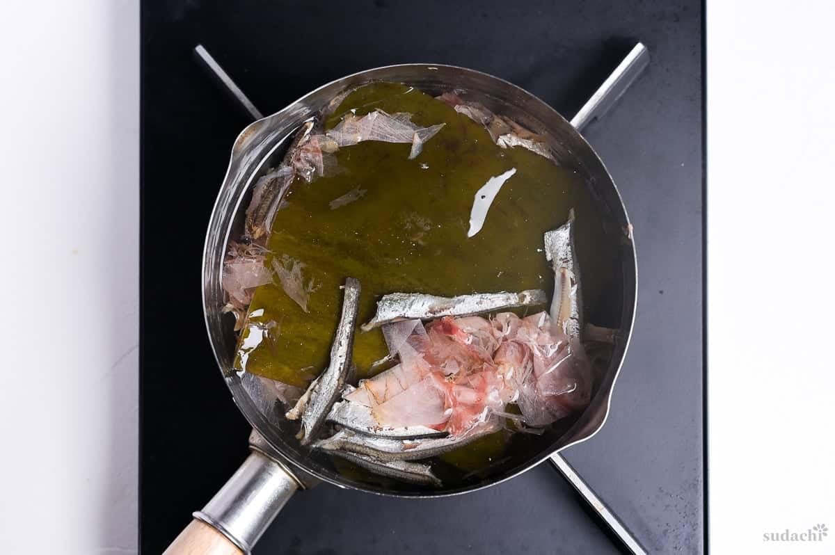 spent dashi ingredients in a pot of fresh water in a pot on the stove top to make a second batch of dashi (niban dashi)