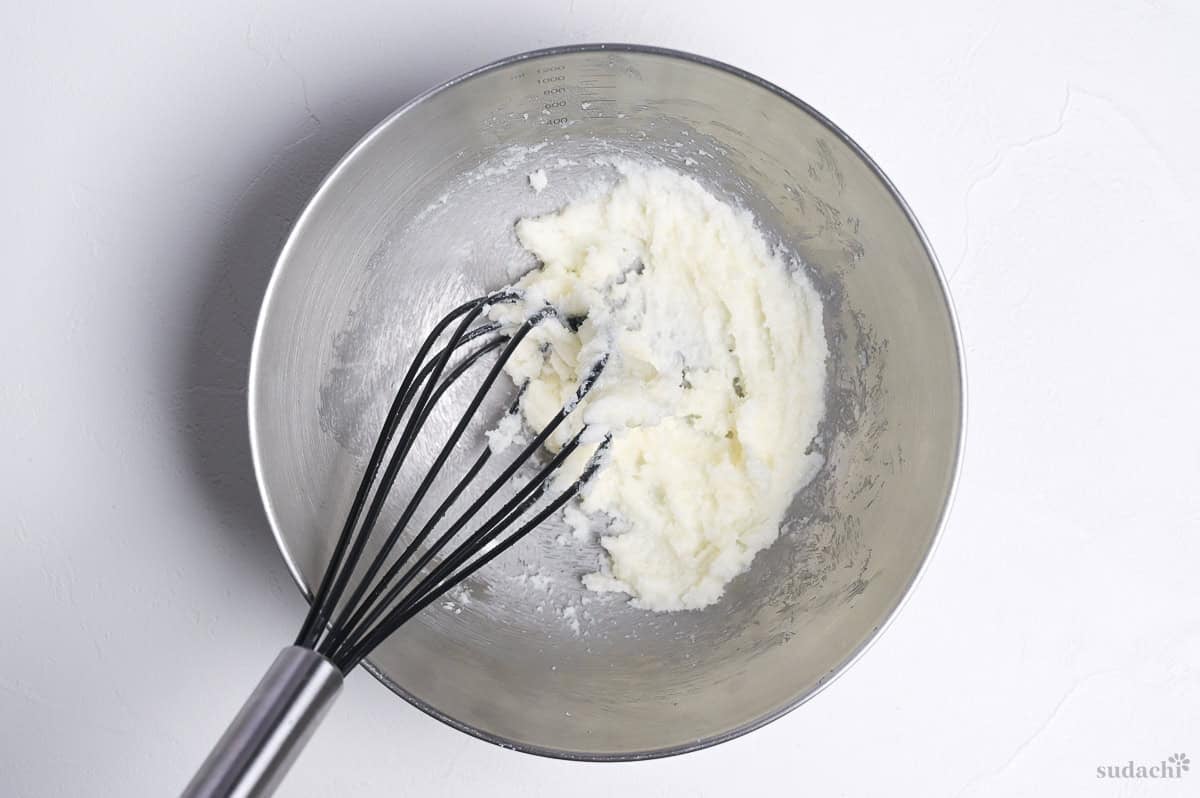 butter and sugar creamed in a steel mixing bowl with whisk