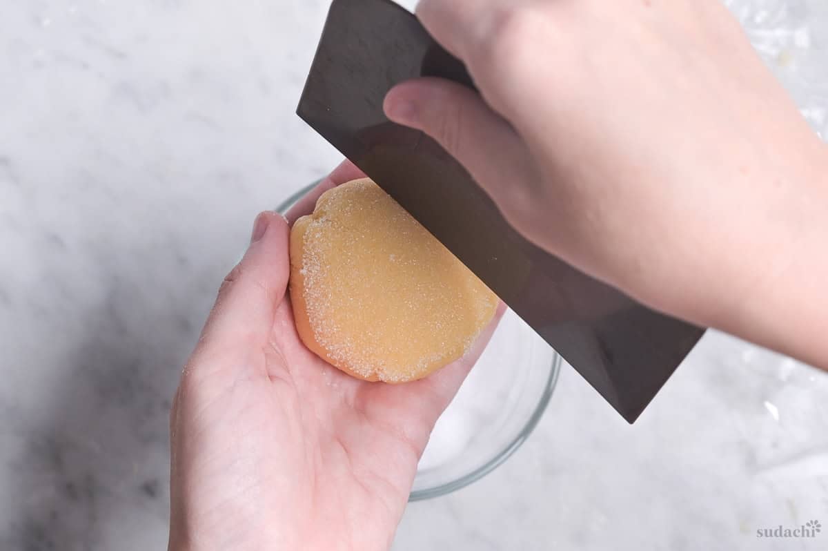 pressing incisions in melon pan cookie dough with plastic bench scraper