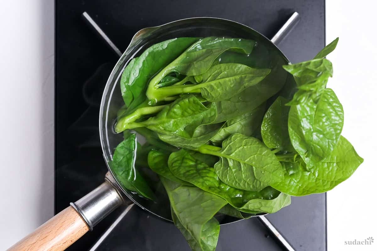 blanching greens in a pot of boiling water