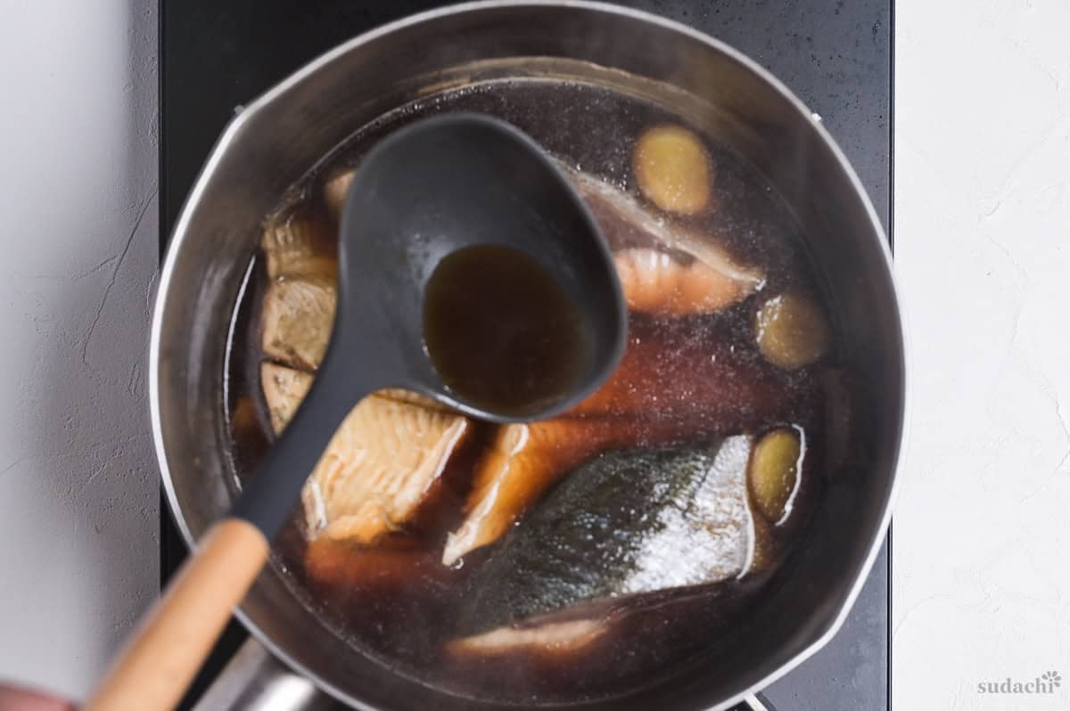 a ladle with broth over a pot of sakana no nitsuke