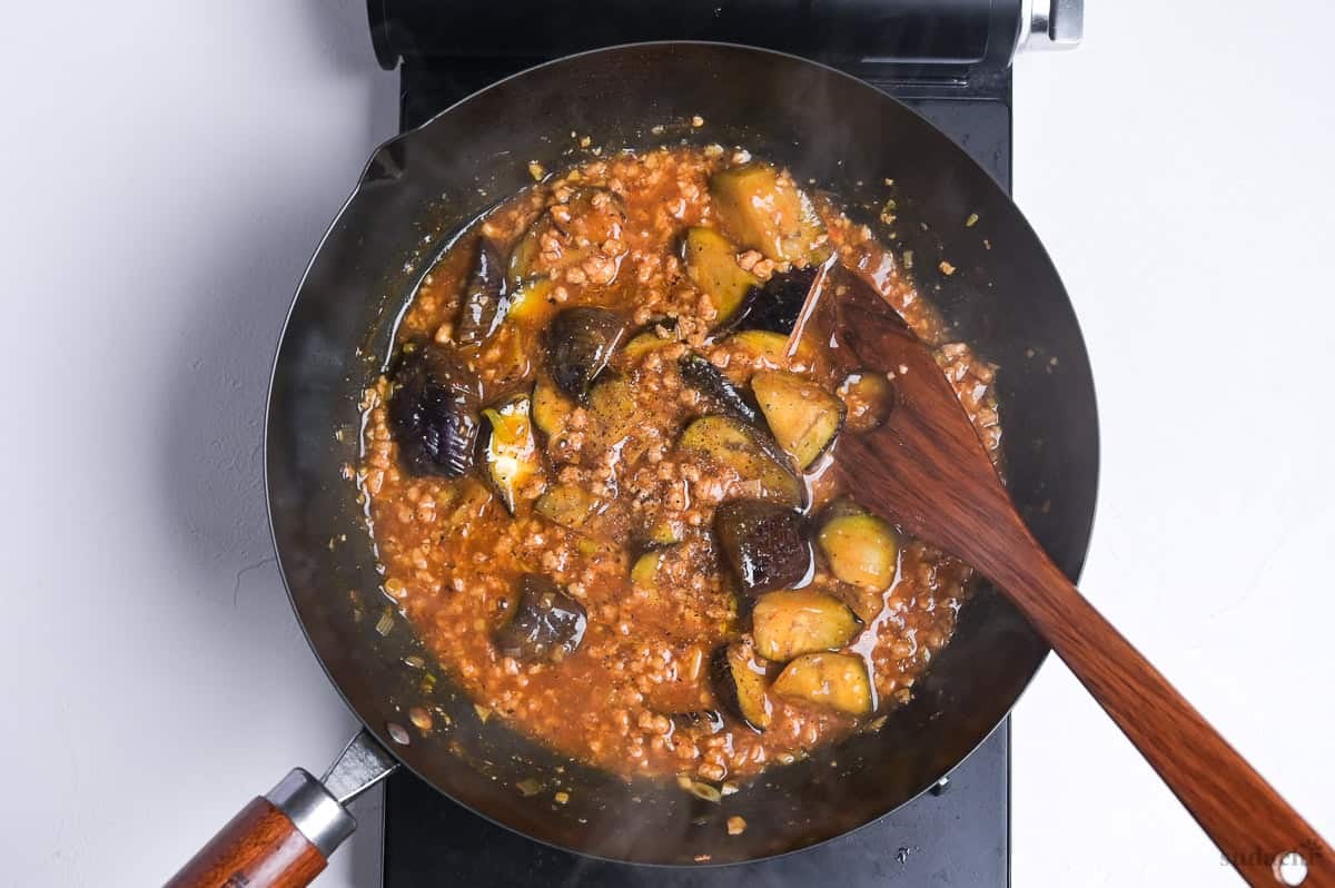plant-based mabo nasu seasoned with ground black pepper in a wok on the stove top