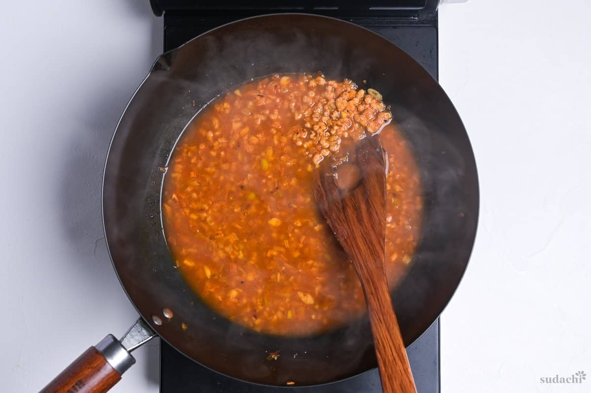 stock added to wok to make broth for plant-based mabo nasu