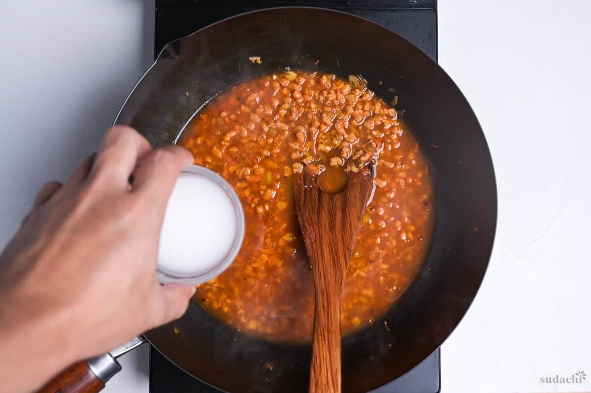 thickening sauce for mabo nasu with a slurry made with starch mixed with water