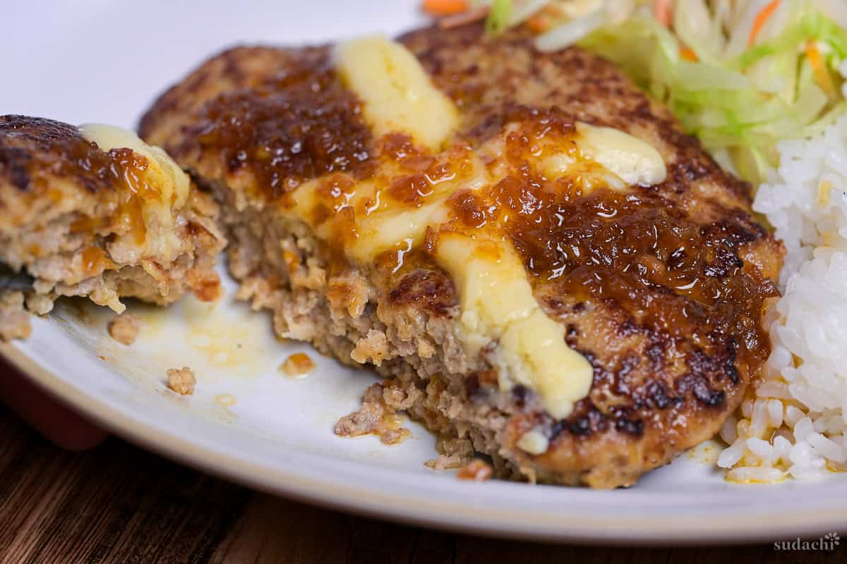Bikkuri Donkey Inspired hamburg steak topped with a cross of melted cheese, cut open to reveal inside