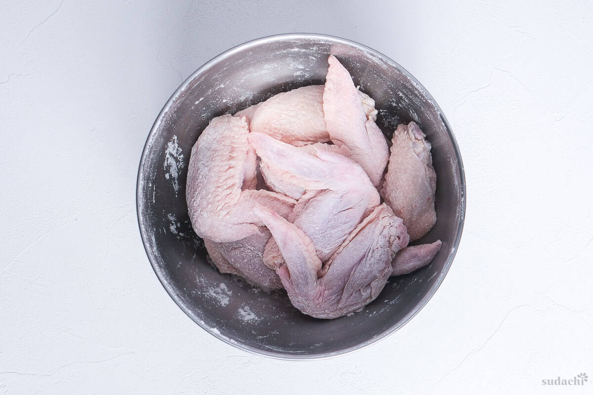 chicken wings coated with starch in a bowl to make yamachan style tebasaki
